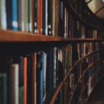 Warm-toned image of curved library bookshelves filled with books in Stockholm.